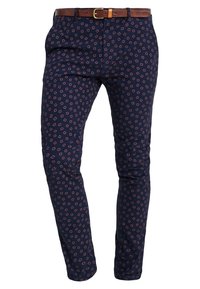 Navyblauwe slim-fit broek met een rood geometrisch vierkantpatroon en een bruine leren riem met een gouden gesp.