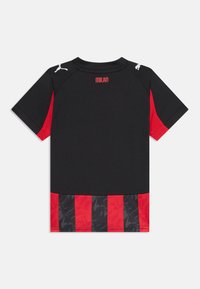 Chemise noire à manches courtes avec des accents rouges, présentant une partie inférieure à rayures noires et rouges et le logo Puma sur les épaules.