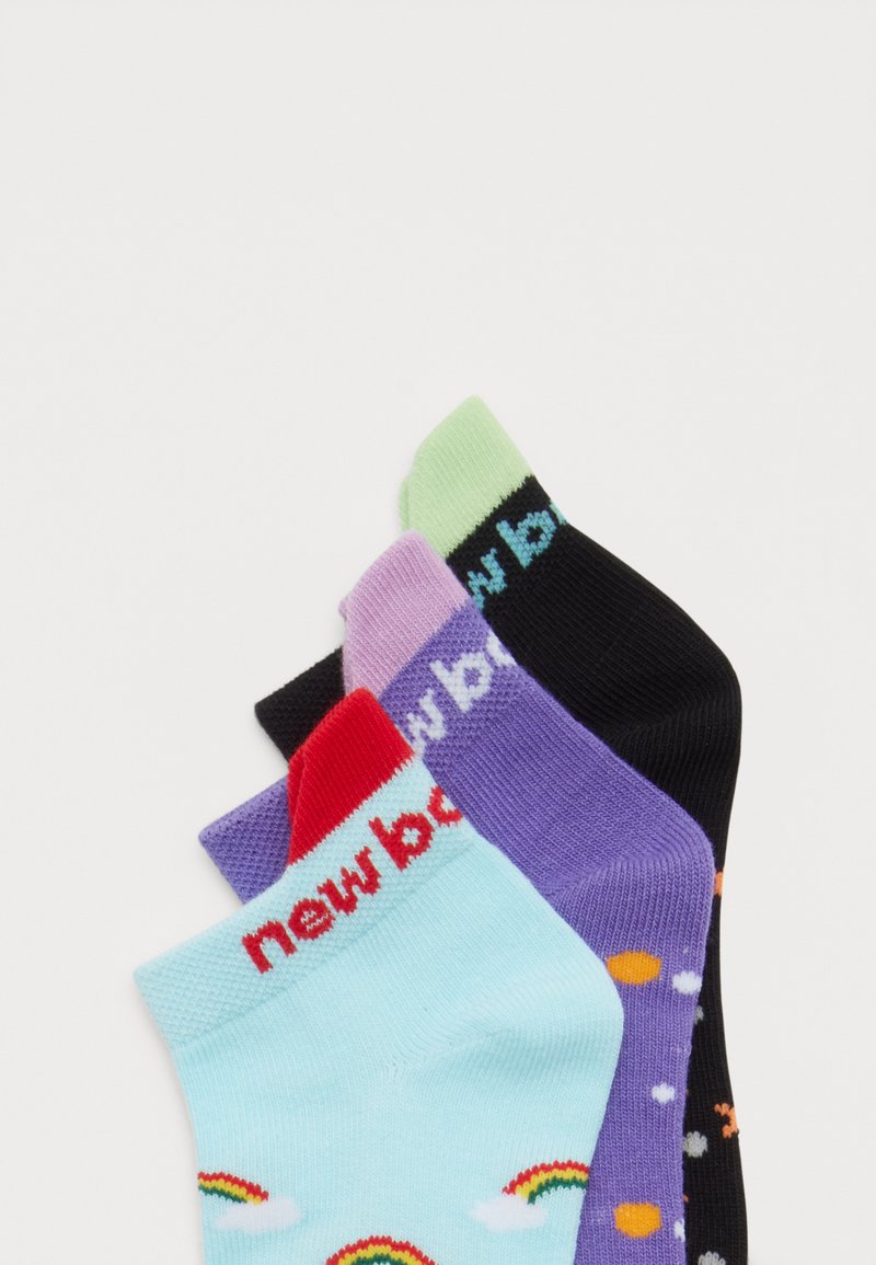 Tre calzini colorati alla caviglia impilati: azzurro con arcobaleni, viola con pois e nero con tallone verde e testo blu.