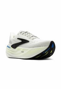 White athletic shoe with a textured upper, black and blue accents, cushioned sole, and unique wave design on the outsole for enhanced traction.