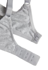 Sujetador de tela gris con tirantes ajustables, diseño sin costuras y cierre de tres ganchos en la parte posterior para un ajuste seguro.