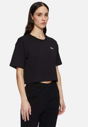 Camiseta negra corta de algodón, con mangas cortas yescote redondo, con un logo blanco de FILA en el lado izquierdo del pecho.