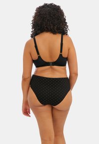 Černá podprsenka s nastavitelnými ramínky a zapínáním na zadní straně, kombinovaná s černými bikiny s vysokým pasem a strukturovaným vzorem.