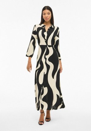 Robe longue noire et crème avec un devant à boutons, un col, des manches trois-quarts et un motif ondulé, fabriquée en tissu léger.