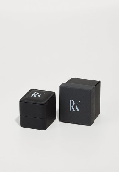 Black jewelry box with a textured finish, featuring a padded lid, silver logo, and a two-part design for storage.