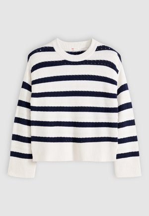 Fehér kötött hosszú ujjú pulóver széles vízszintes tengerészkék csíkokkal, bordázott mandzsettákkal és szegéllyel, szürke háttéren laposan elhelyezve.