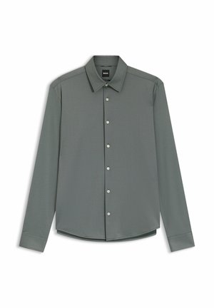 Långärmad skjorta i dämpad grön tyg, med knappkrage och knäppning framtill. Slät textur med subtil lyster.