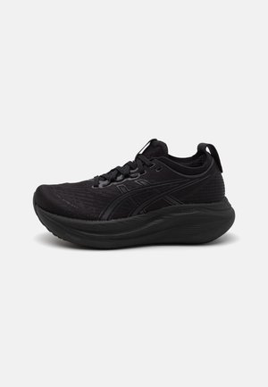 Baskets de sport noires avec une tige en mesh texturé, des lacets plats, un renfort au niveau des orteils et une semelle épaisse et rembourrée pour un soutien accru.