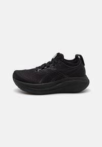 Black athletic shoe featuring a mesh upper, cushioned sole, and textured design. Lace-up closure and pull tab at the heel.
