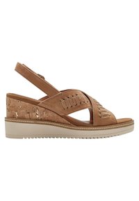 Sandali con zeppa color tan, caratterizzati da una base in sughero, cinturini incrociati e un design texturizzato. Il tacco è alto circa 5 centimetri.