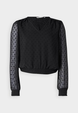 Musteline lühike topp V-kaelusega, tekstureeritud kangast, täppide mustriga, läbipaistvate pikkade varrukatega ning elastsete mansettide ja hemiga.