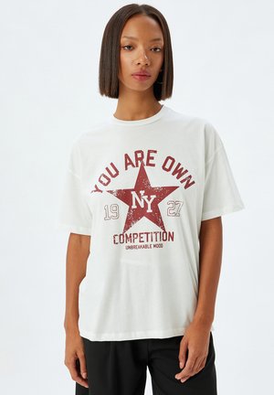 Witte katoenen t-shirt met rode grafische print met een ster, de tekst "YOU ARE OWN" en "COMPETITION." Ronde hals, korte mouwen, gebreide pasvorm.