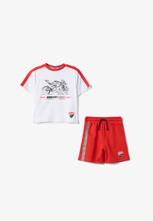 T-shirt blanc et rouge à manches courtes avec motif moto et short rouge avec bande à damier et taille à cordon.