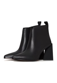 Botas de cuero negro hasta el tobillo con puntera puntiaguda y un tacón cuadrado grueso. Textura suave con lengüetas de agarre para facilitar su uso.