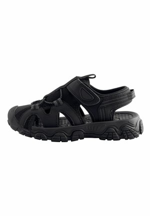 Czarny, zamknięty sandał na zewnątrz z regulowanymi paskami, oddychającymi siateczkowymi bokami i grubą, teksturowaną podeszwą przeznaczoną na nierówne tereny i zapewniającą komfort.