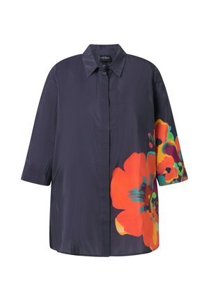 Długi ciemnogranatowy płaszcz z dużym, żywym pomarańczowym i wielobarwnym kwiatowym nadrukiem na dolnej części przodu i prawym rękawie.
