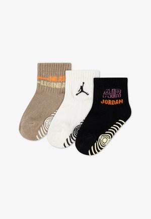 Tri páry detských členkových ponožiek v hnedej, bielej a čiernej farbe s logami značky Jordan a protišmykovými vzormi na podrážkach.