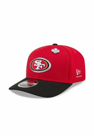 Rot-schwarze San Francisco 49ers Kappe mit NFL Draft 2022 Pin und New Era Logo an der Seite, dargestellt auf weißem Hintergrund.