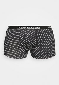 Fekete boxer short egy rugalmas derékrésszel, melyen ismétlődő "URBAN CLASSICS" felirat található. Puha, elasztikus anyag, ami jól fekszik.