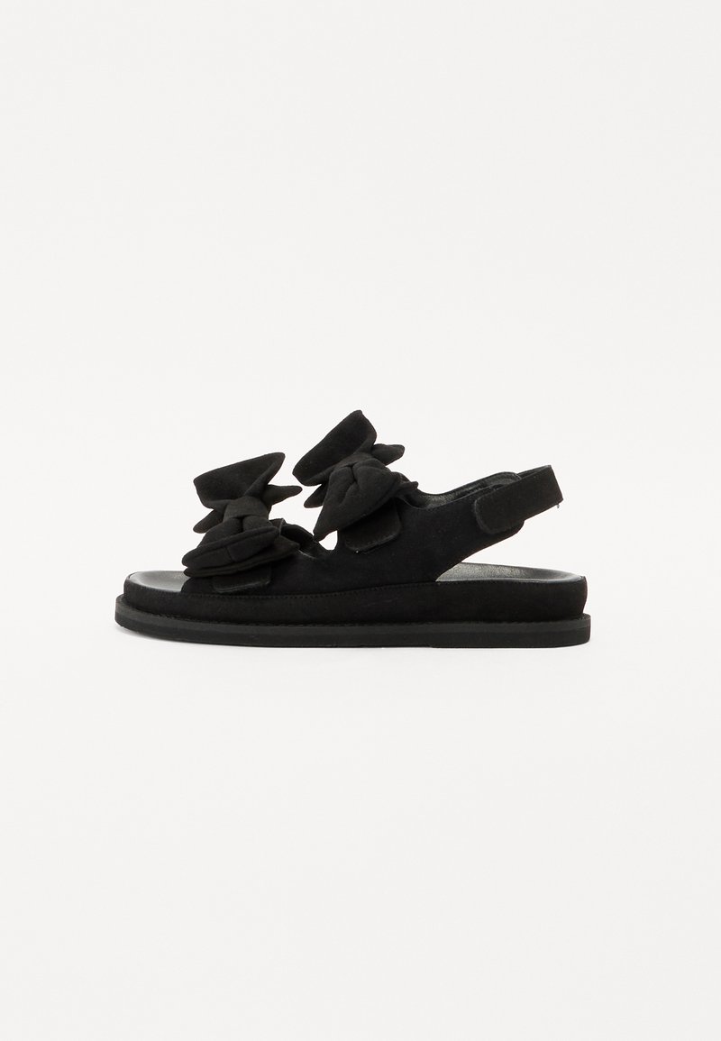 Mustad suede sandaalid lame tallaga, millel on kolm suurt lillemotivi peal ja avatud seljaosa mugavaks selga panemiseks.