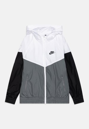 Lekka kurtka z kapturem Nike z białą górą, szarym przodem, czarnymi rękawami, zamkiem błyskawicznym z przodu oraz kieszeniami bocznymi na zamek.