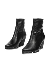 Botines de cuero negro con punteras puntiagudas, cremalleras laterales, borde con tachuelas y tacones de cuña apilados.