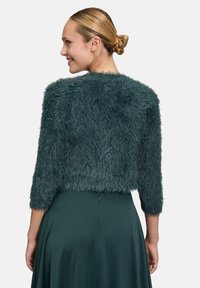 Türkisfarbene Kunstfelljacke mit einem cropped Design und Dreiviertelärmeln, die eine weiche Textur und einen runden Ausschnitt bietet.