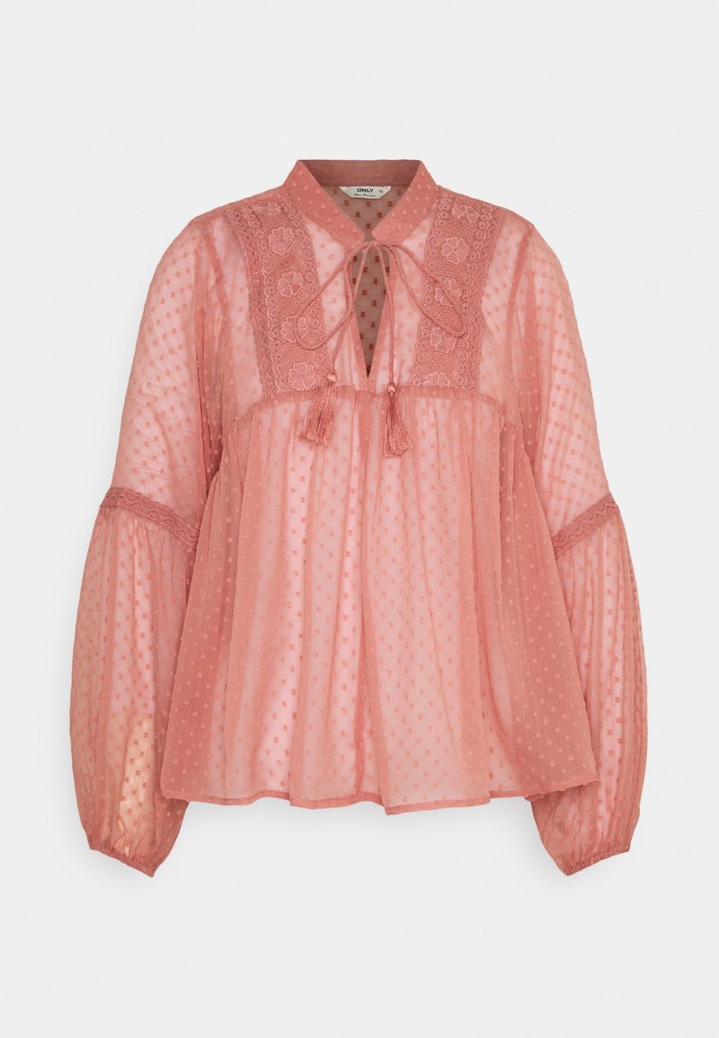 Blouse rose clair en tissu transparent à pois. Comprend un col, un nœud à l'avant et des manches longues volumineuses avec des accents en dentelle.