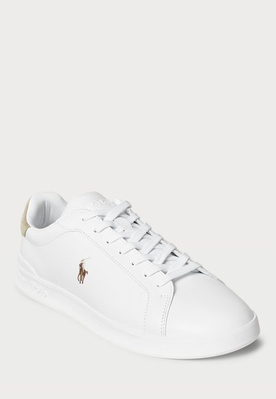 Valge nahkne madal sneaker valgete paeltega, beež nahast kand ja väike tikitud polo mängija logo küljel.