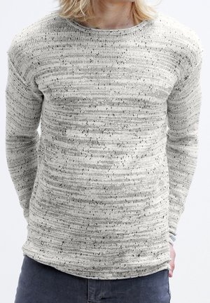 Suéter de punto gris claro con rayas texturizadas y pequeñas motas negras. Cuenta con un cuello redondo y mangas largas. Ajuste suave y relajado.