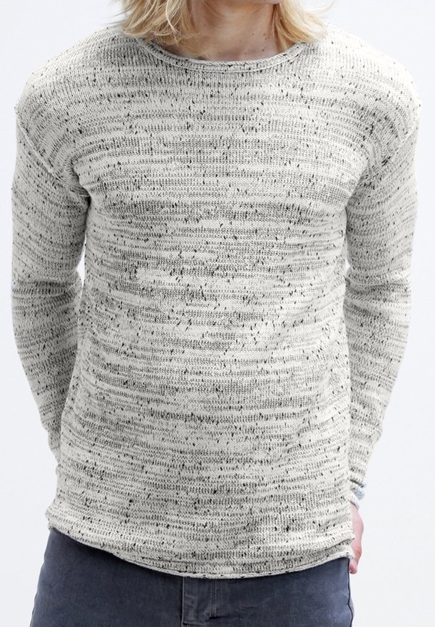 Ljusgrå stickad tröja med strukturerade ränder och små svarta fläckar. Har en rund halsringning och långa ärmar. Mjuk, avslappnad passform.