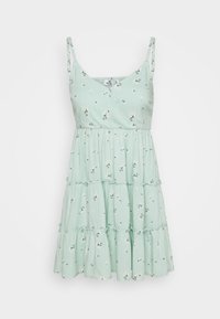 Ljusgrön, lager-på-lager klänning med spaghetti-band, som har ett blommönster och en omslagsdesign vid bysten. Mjuk tyg och avslappnad passform.