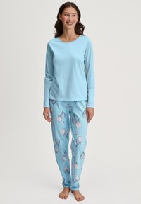 Lichtblauw, lange mouw, pyjama bovenstuk gecombineerd met bijpassende onderstukken met een patroon van geïllustreerde luchtballonnen in tinten blauw en grijs.
