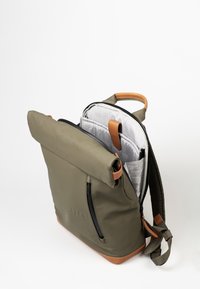 Zaino roll-top di colore verde oliva con dettagli in pelle marrone. Presenta una tasca anteriore con zip e un interno a motivo a rete con numerosi scomparti.