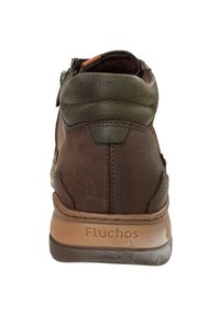 Bottine en cuir marron avec des accents vert olive, dotée d'une fermeture éclair sur le côté et d'une finition texturée. Marque Fluchos sur la semelle.