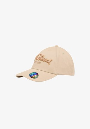 Beige baseball cap med broderet logo og år. Buet skygge og et holografisk klistermærke på siden. Glat stoffets tekstur.