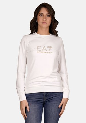 Sweatshirt blanc à manches longues avec un col rond, arborant le logo "EA7 Emporio Armani" en strass à l'avant. Tissu lisse, design ajusté.