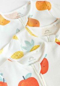 Tre babytidningar i vitt tyg med orange- och ananastryck. Varje har en rundad halsringning och dragkedja fram.