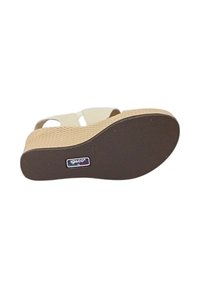 Sandal in pelle beige con piattaforma e suola testurizzata, dotata di due fasce incrociate e punta arrotondata. Logo visibile sulla suola.