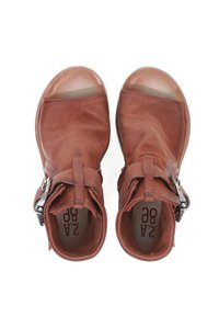 Brune læder ankelstøvler med en glat finish, der har detaljer med spænde og åbne tæer. Sålerne er runde og let gennemsigtige.