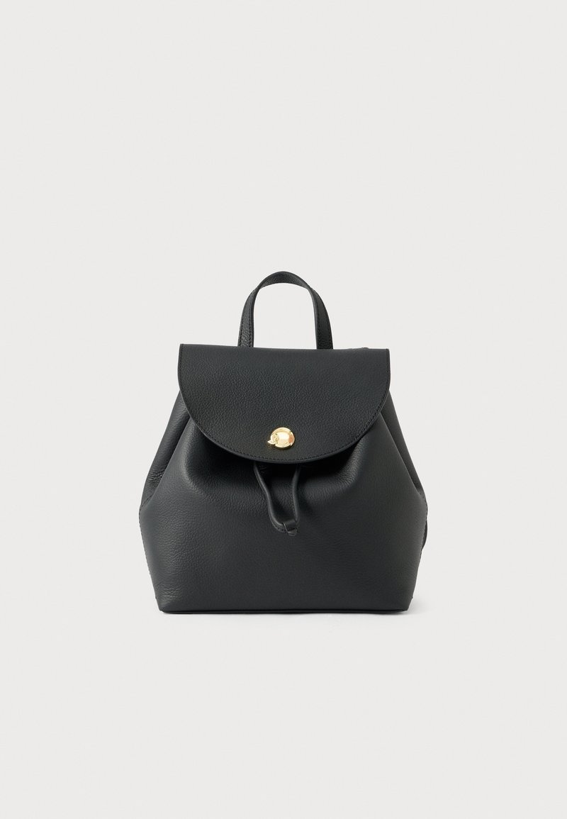 Sac à dos en cuir noir avec un rabat maintenu par une fermeture dorée et une poignée supérieure, sur un fond clair uni.