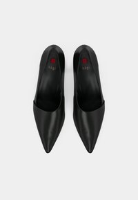 Black leather pointed-toe heels with a smooth finish, featuring a subtly curved silhouette and a small red logo detail inside.