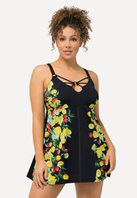 Zwart badpakjurk met levendig geel en rood fruitpatroon. Heeft kruislings straps en een aansluitend lijfje dat uitloopt bij de taille.