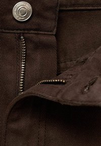 Brown cotton fabric with a visible zipper, button hardware, and diagonal ribbed texture. Interior view showing stitching details and pocket opening.