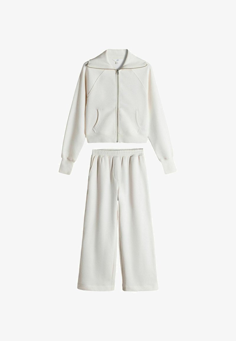 White two-piece outfit with long-sleeve zip-up jacket and wide-leg elastic waist pants, displayed on a white background.