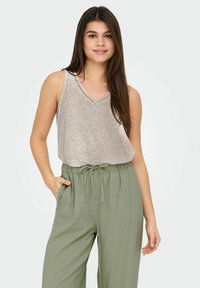 Top gris sin mangas con escote en V y un sutil ribete, combinado con pantalones holgados en verde oliva que tienen una cintura elástica y bolsillos.