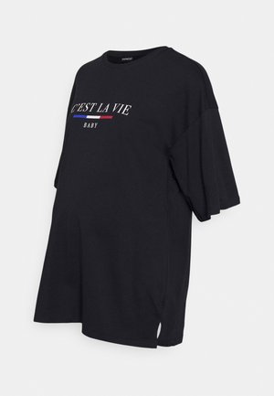 Zwart oversized zwangerschaps-T-shirt met korte mouwen, ronde hals en witte tekst "C'EST LA VIE BABY" met blauwe en rode strepen op de borst.