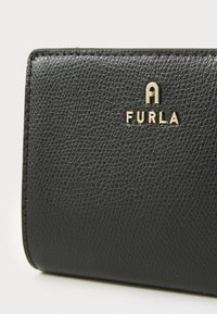 Black textured leather wallet featuring a gold-tone "FURLA" logo. Compact rectangular shape with a smooth finish and subtle details.