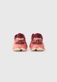 Men's sport shoes with a maroon mesh upper and pink sole, featuring textured panels and yellow logo accents, designed for traction.