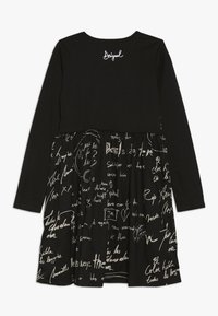 Czarna długa sukienka z długim rękawem i marszczonym dołem, z białym tekstem w stylu odręcznym oraz haftowanym białym logiem "Desigual" w pobliżu dekoltu.